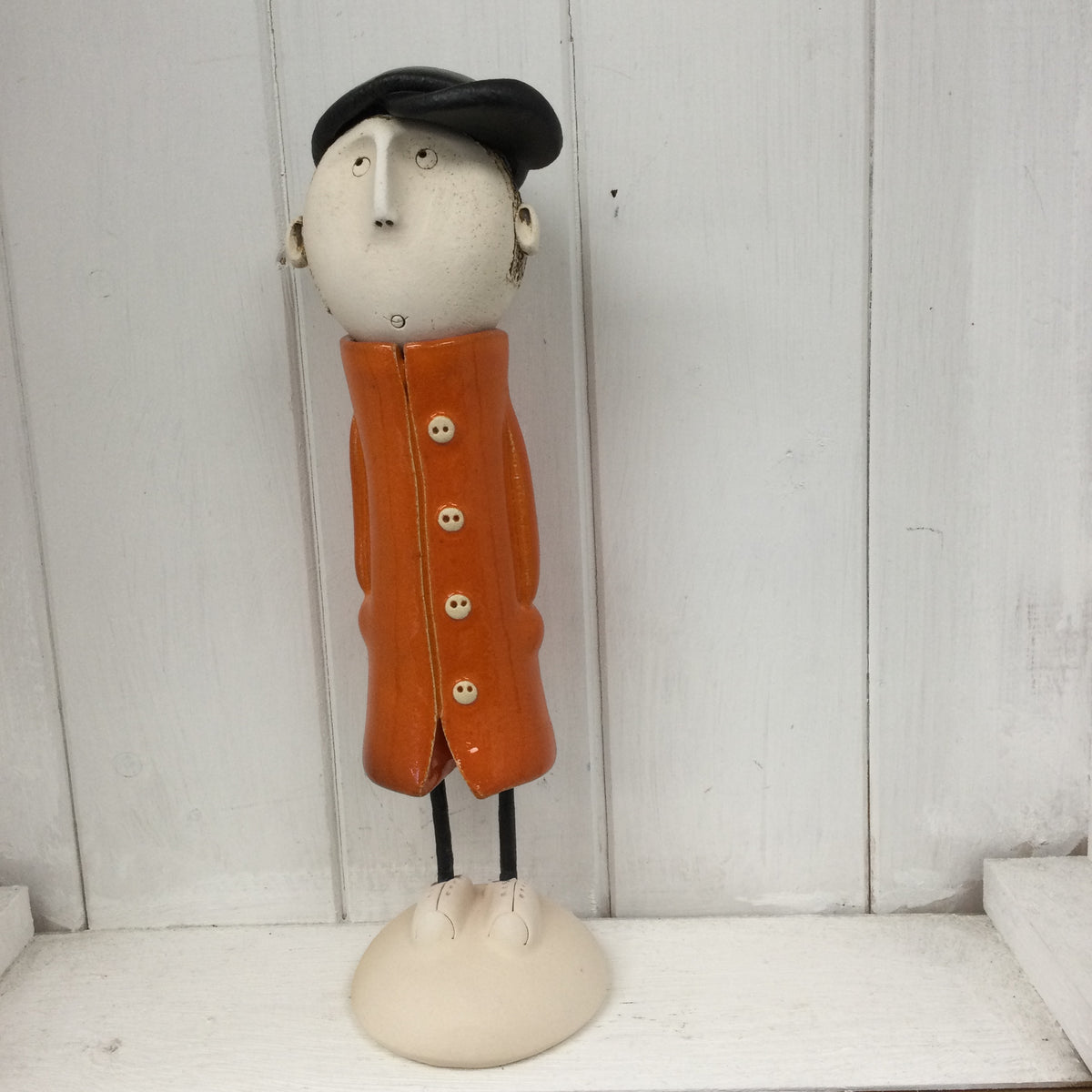 Ceramic Man in an orange great coat.