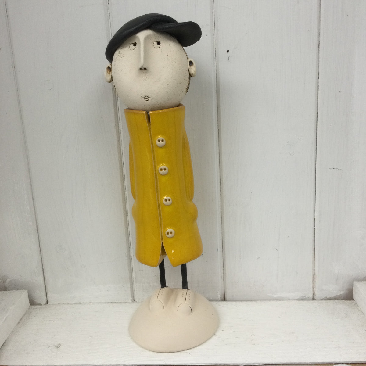 Ceramic Man in a yellow great coat.