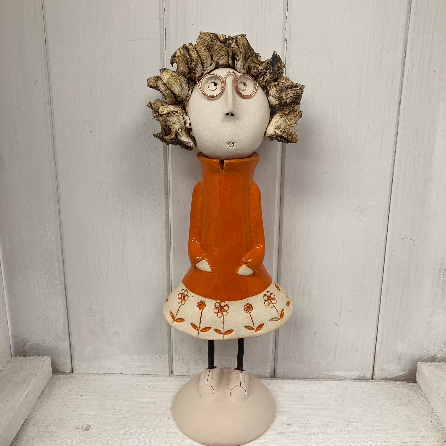 Ceramic Girl with spiky hair and glasses in an orange dress